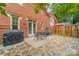 Brick backyard featuring a stone patio and a black metal table with four chairs at 984 Park Slope Dr, Charlotte, NC 28209