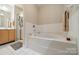 Bright bathroom featuring a large bathtub and separate glass shower at 984 Park Slope Dr, Charlotte, NC 28209