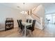 Bright dining room featuring modern chandelier, glass table, and stylish decor next to the staircase at 984 Park Slope Dr, Charlotte, NC 28209