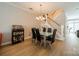 Dining room with glass table, modern chairs, liquor cabinet and open staircase at 984 Park Slope Dr, Charlotte, NC 28209