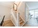 Hallway with staircase, light wood floors, and neutral paint leading to kitchen and dining area at 984 Park Slope Dr, Charlotte, NC 28209