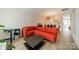 Bright living room with orange couch, hardwood floors, and staircase at 984 Park Slope Dr, Charlotte, NC 28209