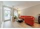Bright living room with modern orange sofa, hardwood floors, and a large window for natural light at 984 Park Slope Dr, Charlotte, NC 28209