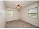 A sunlit bedroom featuring carpet floors, a ceiling fan, and windows offering views of the surrounding area at 1025 Hefner Nw Dr, Conover, NC 28613