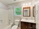 Bathroom with a shower-tub, wooden framed mirror, toilet, and window at 104 Aurora Ln, Huntersville, NC 28078