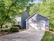 View of the home and detached garage with white doors and blue siding at 104 Aurora Ln, Huntersville, NC 28078