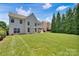 Beautiful backyard with lush grass, mature trees, and a patio, creating a serene outdoor space at 105 Runningdeer Dr, Mooresville, NC 28117