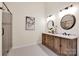 Bright bathroom featuring double sinks, marble countertops, and a frameless glass shower at 105 Runningdeer Dr, Mooresville, NC 28117