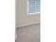 Image shows a room with light beige carpet, baseboards, and a window with white blinds at 105 Runningdeer Dr, Mooresville, NC 28117