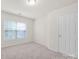 Bedroom with neutral walls and carpet, featuring two windows, a white door, and neutral carpet at 105 Runningdeer Dr, Mooresville, NC 28117