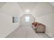 Bright bonus room featuring neutral walls, carpet, and a comfortable, cushioned couch with pillows at 105 Runningdeer Dr, Mooresville, NC 28117