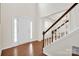 Bright foyer featuring hardwood floors, a staircase, and an entrance with white door at 105 Runningdeer Dr, Mooresville, NC 28117