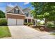 Two-story home with a two-car garage and well-kept lawn with an inviting driveway and walkway at 105 Runningdeer Dr, Mooresville, NC 28117