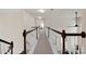 Second story hallway featuring wood and white railing and neutral walls with carpet at 105 Runningdeer Dr, Mooresville, NC 28117