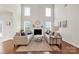 Bright living room with tall windows, fireplace, hardwood floors, and comfortable seating at 105 Runningdeer Dr, Mooresville, NC 28117