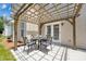 Outdoor patio with wooden pergola over a table and chairs, next to the home's french doors at 105 Runningdeer Dr, Mooresville, NC 28117