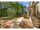 Inviting backyard with a stone patio, mature trees, and a screened-in porch, perfect for outdoor entertaining at 108 Bare Foot Ln, Mooresville, NC 28117