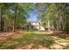 A large backyard with mature trees, and well-maintained landscaping with stone patio at 108 Bare Foot Ln, Mooresville, NC 28117