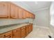 Bright laundry room with granite counters, tile floors, and wood cabinets at 108 Bare Foot Ln, Mooresville, NC 28117