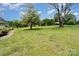 View of the backyard with lush green grass, trees, and blue sky above at 109 Terrace Pl, Lincolnton, NC 28092