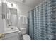 Clean bathroom with a white vanity, toilet, and a shower with a blue and gray patterned curtain at 11139 Dundarrach Ln, Charlotte, NC 28277