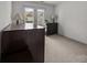 Minimalist bedroom showcasing neutral carpet, gray dressers, and double doors leading to a balcony at 11139 Dundarrach Ln, Charlotte, NC 28277