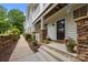 Inviting front porch with a brown door, stone pillars and walkway, and manicured greenery at 11139 Dundarrach Ln, Charlotte, NC 28277