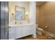A powder bathroom with golden wallpaper, a mirror, sconces and a white vanity at 1118 Jefferson Dr, Charlotte, NC 28270