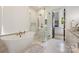Elegant bathroom featuring a freestanding tub, glass shower, and a doorway to a walk-in closet at 1118 Jefferson Dr, Charlotte, NC 28270