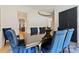 A formal dining room features an elegant light fixture, a dark wood table and blue upholstered chairs at 1118 Jefferson Dr, Charlotte, NC 28270