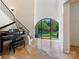 Bright foyer with a grand piano, staircase, and large arched window offering views of the landscaped front yard at 1118 Jefferson Dr, Charlotte, NC 28270