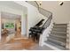 An elegant foyer boasts a curved staircase, grand piano, and views of the adjacent living spaces at 1118 Jefferson Dr, Charlotte, NC 28270