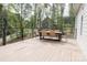 Inviting back deck with sleek railing and outdoor dining set surrounded by trees at 1123 Fern Hill Rd, Mooresville, NC 28117