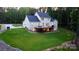 Backyard view of white home with a spacious deck and well-manicured lawn at 1123 Fern Hill Rd, Mooresville, NC 28117