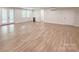 Spacious living room with light wood floors, a built-in bar, and French doors leading to the outdoors at 1123 Fern Hill Rd, Mooresville, NC 28117