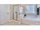 Bright bathroom with a glass-enclosed shower and a luxurious soaking tub under a window at 1151 Donelea Nw Ln, Concord, NC 28027