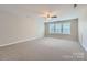 Large bonus room with ample space for recreation or entertainment, featuring a neutral carpet and a ceiling fan at 1151 Donelea Nw Ln, Concord, NC 28027