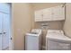 Functional laundry room equipped with a washer, dryer, and ample cabinet storage space at 1151 Donelea Nw Ln, Concord, NC 28027