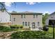 Back exterior showcasing a well-maintained lawn, small patio and outdoor grill at 117 Tom Sawyer Ln, Mount Holly, NC 28120