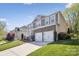 Two-story home with stone accents, siding, two-car garage, and well-maintained lawn at 117 Tom Sawyer Ln, Mount Holly, NC 28120