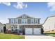 Charming home featuring a covered front porch, stone accents, and a well-maintained lawn at 117 Tom Sawyer Ln, Mount Holly, NC 28120