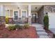Inviting front porch with stone accents, seating, and lush landscaping creating a welcoming entrance at 117 Tom Sawyer Ln, Mount Holly, NC 28120