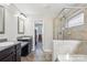 Bright main bathroom with dual sinks, granite counters, and a tiled shower at 117 Tom Sawyer Ln, Mount Holly, NC 28120