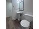 Bathroom features a toilet, a vanity sink and flooring is updated with modern wood look at 12719 Cottonville Rd, Norwood, NC 28128