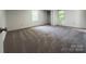 Bedroom features neutral carpet, base trim, and windows bringing in natural light at 12719 Cottonville Rd, Norwood, NC 28128