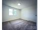 Bright bedroom features a window, neutral walls, and plush carpeting at 12719 Cottonville Rd, Norwood, NC 28128