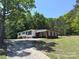 Charming home with a long driveway nestled in a wooded setting providing privacy and natural beauty at 12719 Cottonville Rd, Norwood, NC 28128