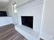 Close-up of a painted white brick fireplace with modern flooring and neutral wall color at 12719 Cottonville Rd, Norwood, NC 28128