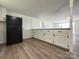 Kitchen view showcases black refrigerator, white cabinets, and wood-look flooring at 12719 Cottonville Rd, Norwood, NC 28128