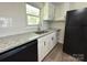 Kitchen features stainless steel sink, granite countertops and black refrigerator at 12719 Cottonville Rd, Norwood, NC 28128